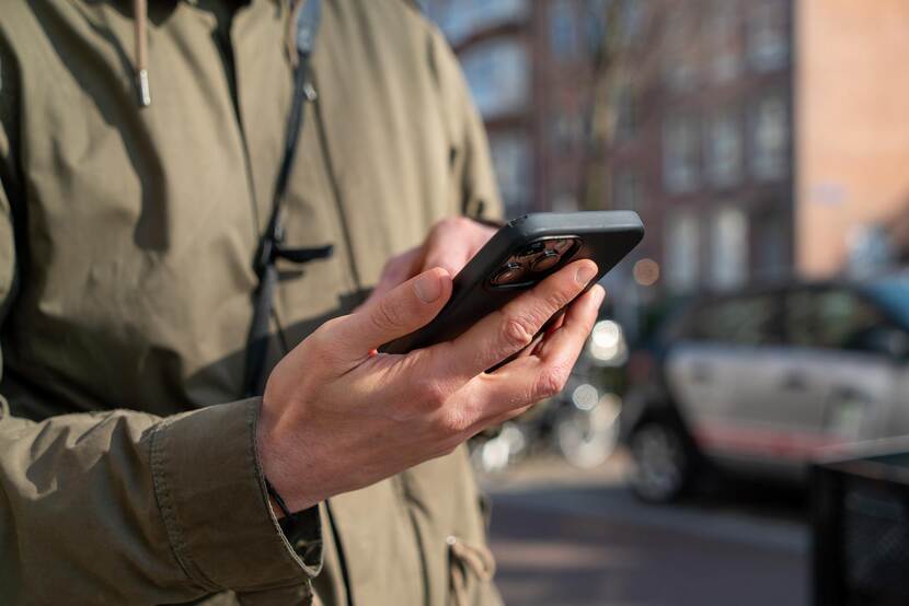 Iemand verstuurt een bericht via een mobiele telefoon