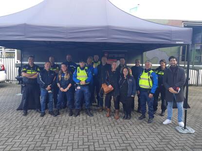 Groep mensen staan onder een partytent.